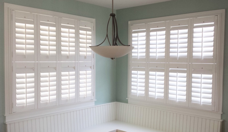 Pastel green wall in San Diego kitchen with shutters.